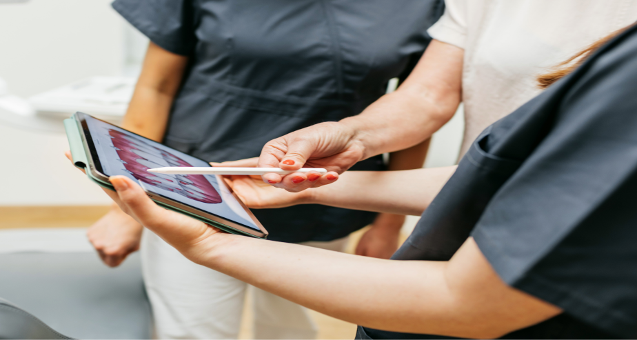 Três pessoas a olhar atentamente para um tablet